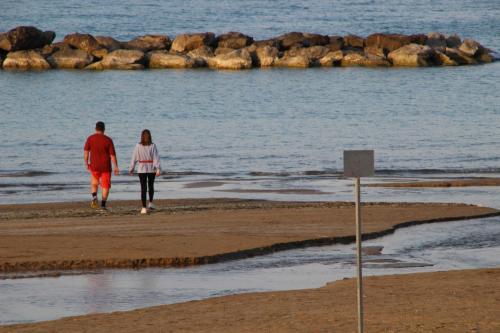a man and a woman walking on the beach at Prati di Maja B&B in Miglianico
