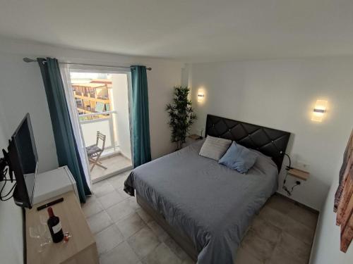 a bedroom with a bed and a television and a window at Casa Leya Los Cristianos in Arona