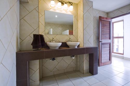 a bathroom with two sinks and a mirror at Hotel Mozonte in Managua