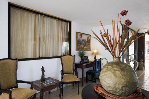 a living room with a vase with flowers in it at Hotel Mozonte in Managua