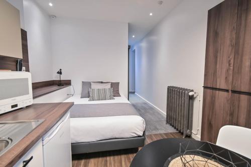 a small room with two beds and a kitchen at Les cles du 27 Paris in Paris