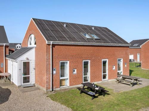 a brick building with a picnic table and two benches at Apartment Odger - 2-3km from the sea in Western Jutland by Interhome in Sønderby