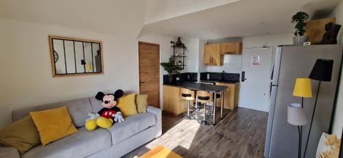 a living room with a couch and a kitchen at La magie Disney à 5 min Superbe & Cosy Appartement 4 personnes in Magny-le-Hongre