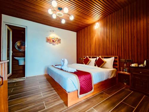 a bedroom with a large bed with wooden walls at WOW STAYZ2 Ashoka Grand in Dalhousie