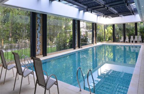 a large swimming pool with chairs and windows at Guangdong Yingbin Hotel-Free Canton Fair Shuttle Bus in Guangzhou