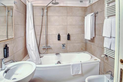 a bathroom with a white tub and a sink at Relais Balcone di Giulietta in Verona