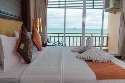 1 dormitorio con 1 cama y vistas al océano en Seaside Jomtien Beach Pattaya, en Jomtien Beach