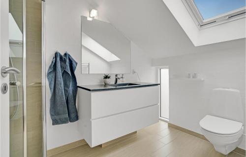 a white bathroom with a sink and a toilet at Nice Home In Juelsminde With Wifi And 2 Bedrooms in Juelsminde