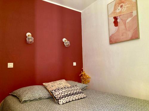 - une chambre avec des murs rouges et un lit avec un oreiller dans l'établissement Les Restanques vue mer 2148, à Grimaud