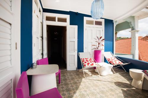 a room with chairs and a table and a blue wall at Villa Amalie & Villa Curiel in Willemstad