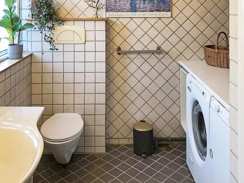 a bathroom with a toilet and a washing machine at Holiday home Gilleleje LXXV in Gilleleje