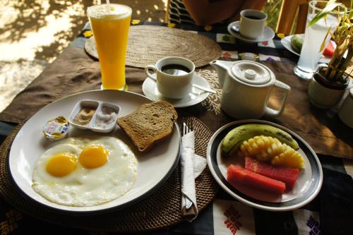 吉利阿尔塞尤克别墅酒店的早餐盘,包括鸡蛋和蔬菜以及一杯橙汁