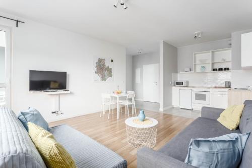 a living room with a couch and a table at Chill Apartments Airport Ursynów in Warsaw