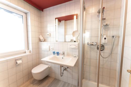a bathroom with a toilet and a sink and a shower at Aparthotel Dorfplatzl Garni in Tux