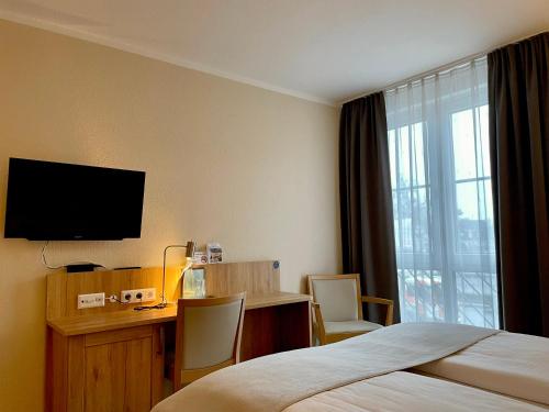a hotel room with a bed and a desk and a television at Businesshotel Berlin in Berlin
