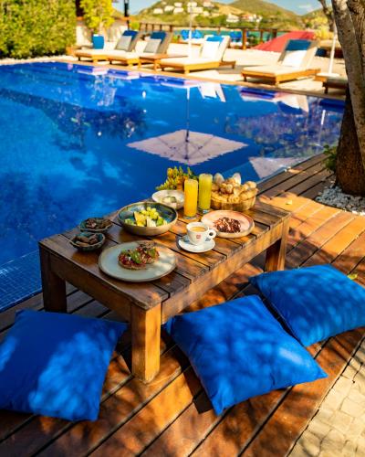 a table with food on it next to a swimming pool at Insólito Boutique Hotel & Spa in Búzios