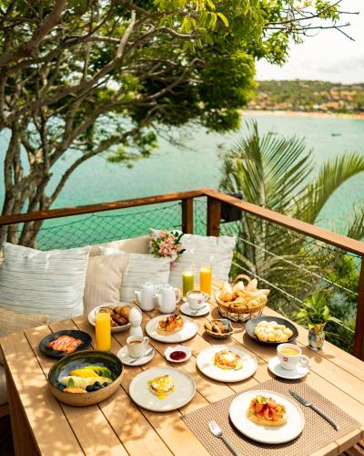 a table with food on it with a view of the water at Insólito Boutique Hotel & Spa in Búzios