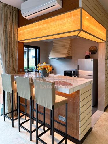 a kitchen with a counter with stools in it at Bonheur at Karambunai in Kota Kinabalu