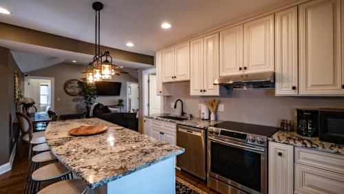 a kitchen with white cabinets and a granite counter top at Cheerful 5-bedroom w/Screened Patio, Sleeps 10 in the heart of Fremont! in Fremont