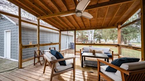 a screened porch with a ceiling fan and chairs and a table at Cheerful 5-bedroom w/Screened Patio, Sleeps 10 in the heart of Fremont! in Fremont