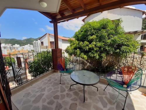 a patio with two chairs and a table on a balcony at Hotel Cabañas Villa Roca, Rodadero in Santa Marta