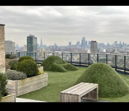 a park with grass domes and a bench on top of a building at Luxurious 2 bedroom apartment in Canary Wharf in London