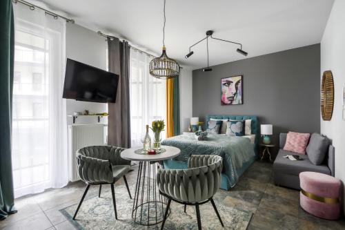sypialnia z łóżkiem, stołem i krzesłami w obiekcie Apartamenty MetroPark Krzemieniecka-Lux w Warszawie