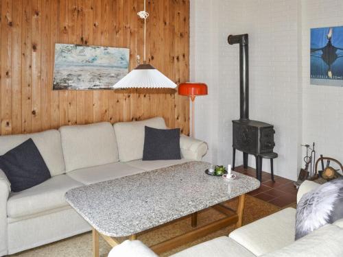 a living room with a couch and a stove at Holiday Home Dorreth - 800m from the sea in Western Jutland by Interhome in Mølby
