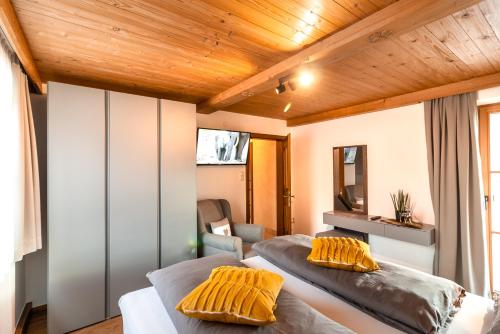 a bedroom with two beds with yellow pillows at Ferienhaus Hetzenauer in Kössen