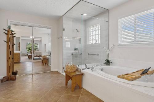 a white bathroom with a tub and a glass shower at Sunset Pass in Middleburg