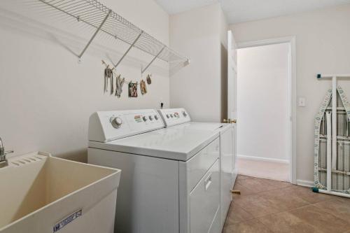 a white laundry room with a washer and dryer at Sunset Pass in Middleburg