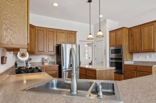 a kitchen with wooden cabinets and a stainless steel refrigerator at Sunset Pass in Middleburg