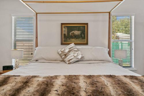 a bedroom with a large bed and two windows at Sunset Pass in Middleburg
