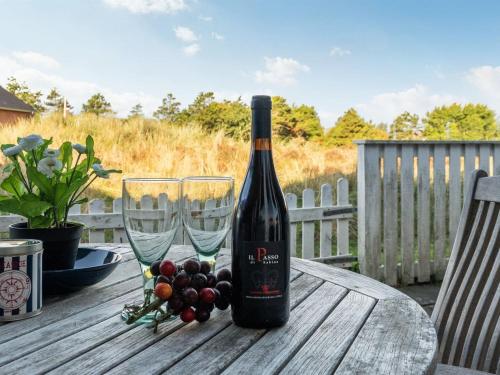 butelkę wina i dwa kieliszki wina na stole w obiekcie Holiday Home Gudbrand - 300m from the sea in Western Jutland by Interhome w mieście Havneby