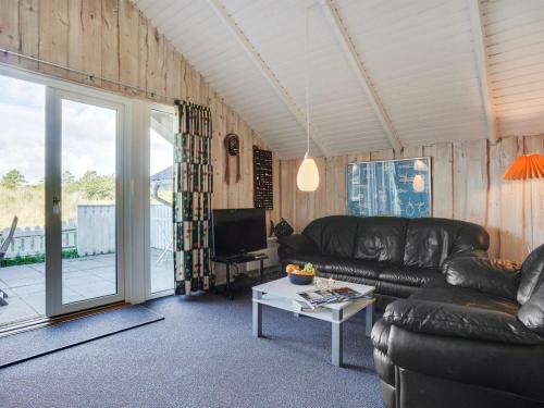 salon ze skórzaną kanapą i telewizorem w obiekcie Holiday Home Gudbrand - 300m from the sea in Western Jutland by Interhome w mieście Havneby