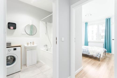 a white bathroom with a washer and dryer at Chill Apartments Airport Ursynów in Warsaw