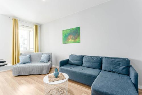 a living room with a blue couch and a chair at Chill Apartments Airport Ursynów in Warsaw