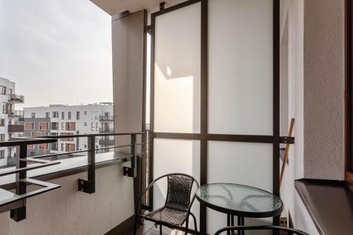 a balcony with two chairs and a table at Chill Apartments Airport Ursynów in Warsaw
