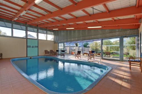 ein großer Pool in einem großen Zimmer mit Fenstern in der Unterkunft Captains Cove Resort - Waterfront Apartments in Paynesville