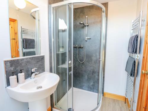 a bathroom with a shower and a sink at Trickett Gate Cottage in Castleton