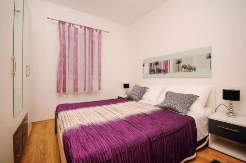 a bedroom with a bed with a purple blanket at House Boze in Vinišće