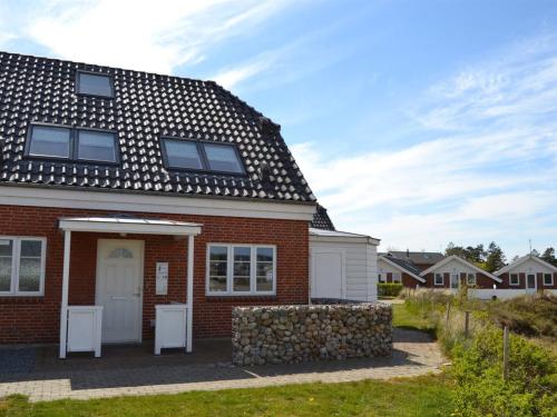 dom z czerwonej cegły z czarnym dachem w obiekcie Holiday Home Harriette - 100m from the sea in Western Jutland by Interhome w mieście Havneby