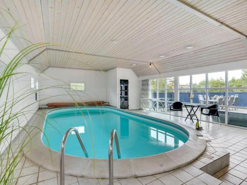 a swimming pool in a house with a ceiling at Holiday Home Madalena - 2-8km from the sea in Western Jutland in Toftum