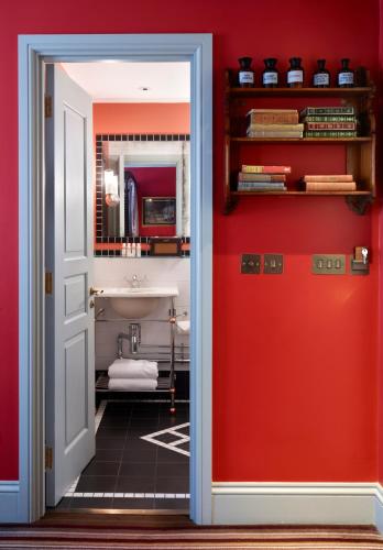 a bathroom with red walls and a red door at The Zetter Clerkenwell in London