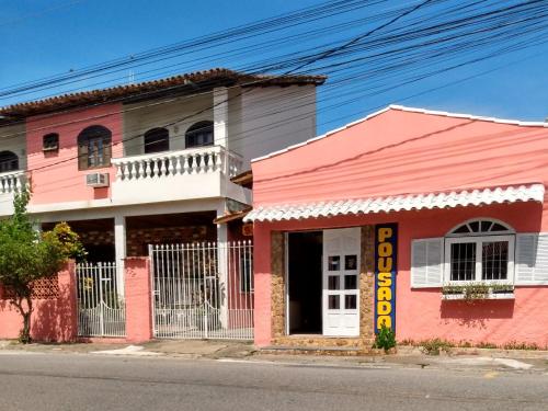 聖佩德羅－達阿爾德亞的住宿－Pousada Sol de Verão，街道边的粉红色建筑
