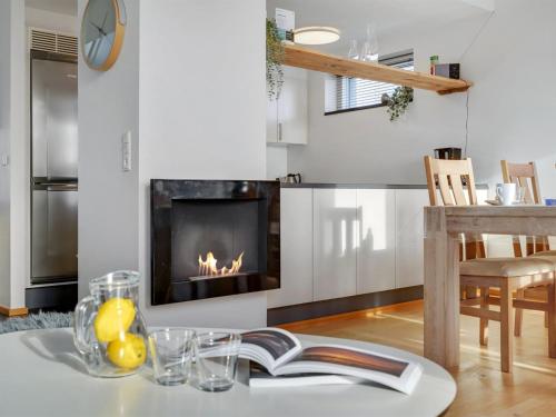 a living room with a fireplace and a table with a book at Apartment Pirkko - 100m from the sea in Western Jutland by Interhome in Havneby
