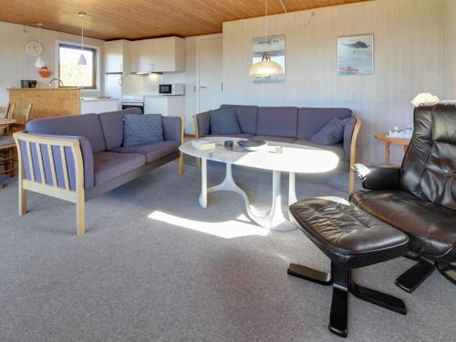 a living room with a couch and a table and chairs at Holiday Home Sara - 2-5km from the sea in Western Jutland by Interhome in Bolilmark