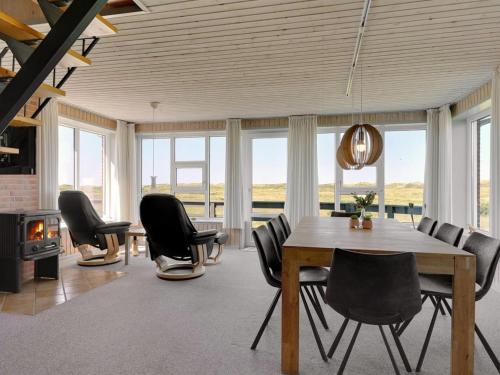 uma sala de jantar com uma mesa e cadeiras e uma lareira em Holiday Home Helfrida - 350m from the sea in Western Jutland by Interhome em Lakolk