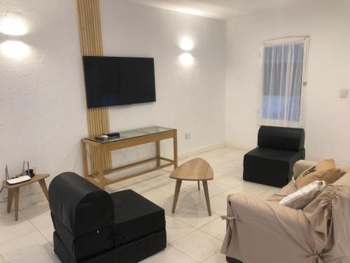 a living room with a couch and a tv at Casablanca Chacras in Chacras de Coria