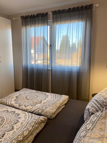two beds in a room with a window at Moderne Wohnung in Heskem bei Marburg (Lahn) 